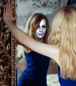 鏡に映る塗装した顔を見る女性