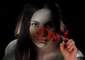 「するな」と書く女性