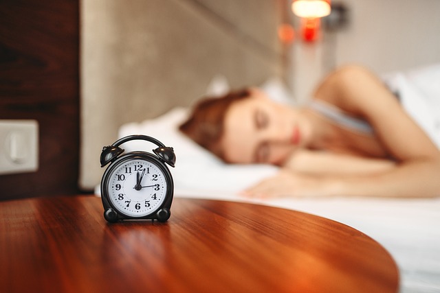 目覚まし時計とベッドで眠る女性